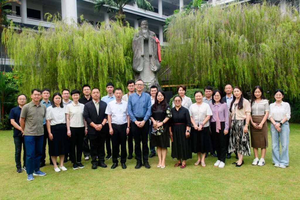 APEC participants standing together outdoors in front of a statue