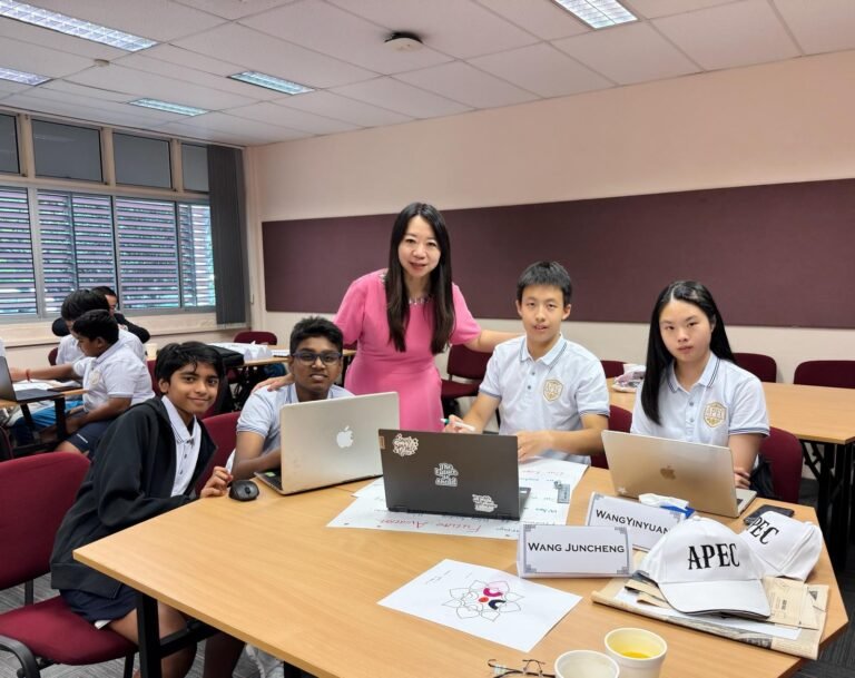 Students and an educator gathered around laptops during an APEC classroom workshop