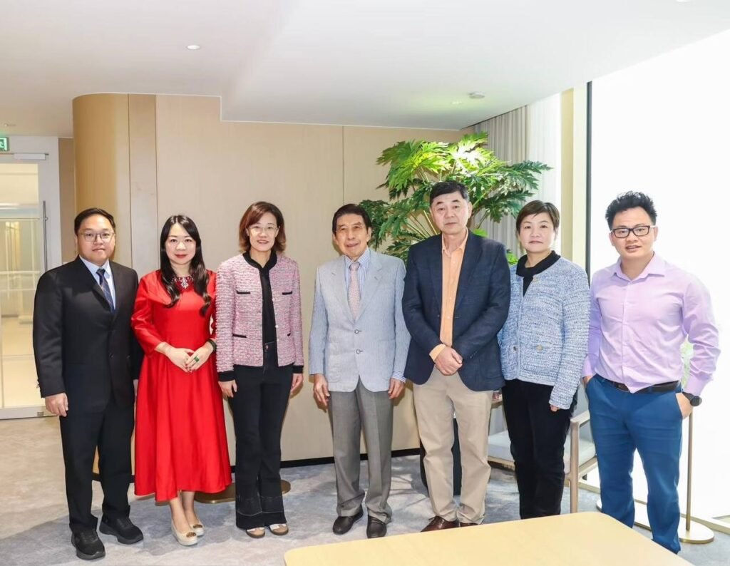 Seven APEC participants standing together indoors